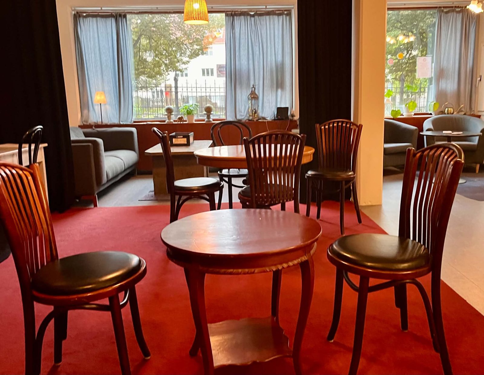Caféet med runda träbord vid de stora fönstren